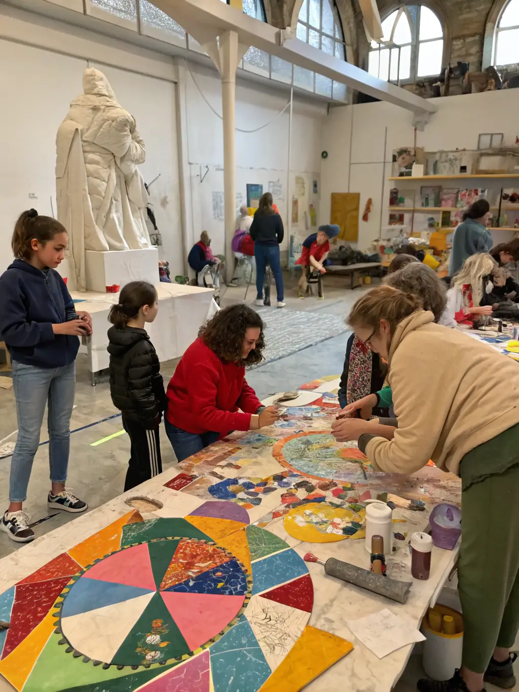 A dynamic scene from a mixed-media art workshop at CENTRE D'ARTS PLASTIQUES DE ROYAN, showing participants experimenting with various materials and techniques.